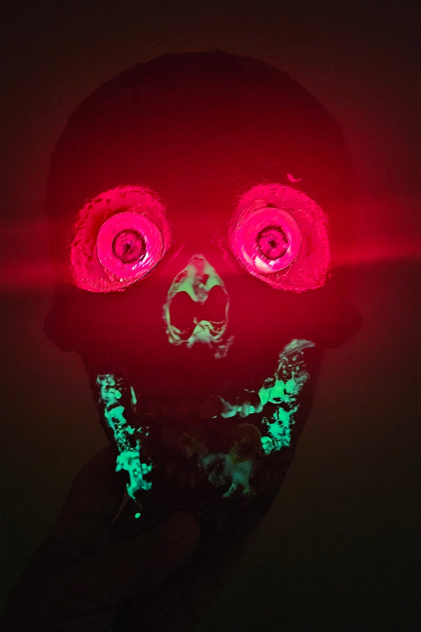 Glowing red and green object in a dark setting